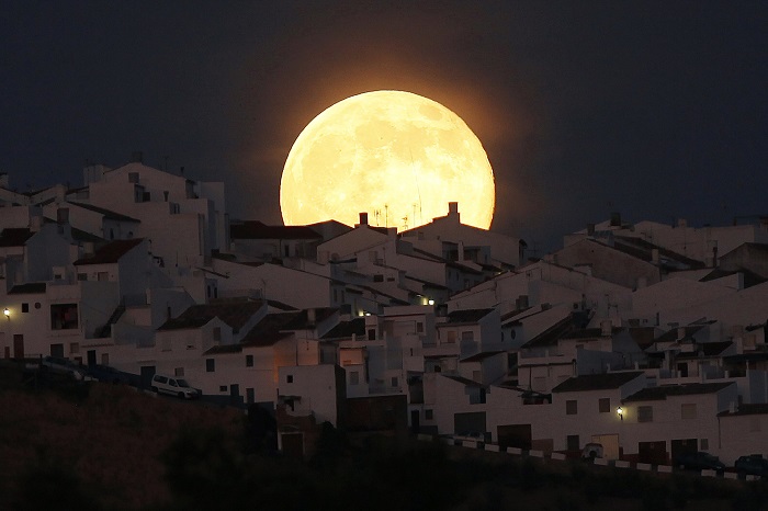 The Supermoon rises over houses in Olvera, in the southern Spanish province of Cadiz, July 12, 2014. Occurring when a full moon or new moon coincides with the closest approach the moon makes to the Earth, the Supermoon results in a larger-than-usual appearance of the lunar disk. REUTERS/Jon Nazca (SPAIN - Tags: SOCIETY CITYSCAPE TPX IMAGES OF THE DAY) ORG XMIT: JN657