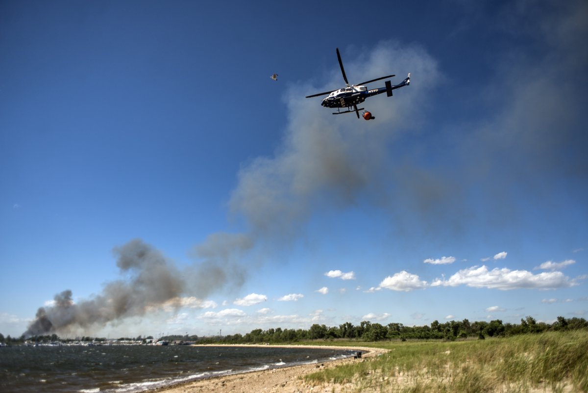 but-in-a-minor-technicality-it-wasnt-firefighters-told-us-that-shrub-land-next-to-the-park-was-on-fire-heres-an-nypd-helicopter-lofting-dirty-bay-water-to-dump-on-the-h